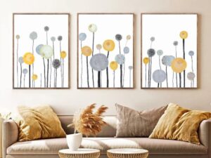Set of 3 vertical canvas paintings featuring abstract yellow and grey flowers on long stems, modern living room wall decor.